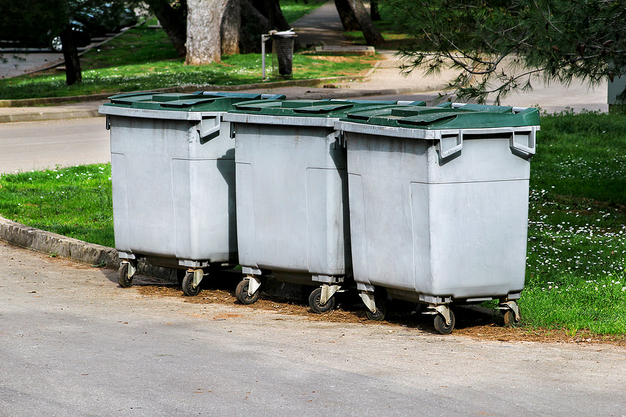 three dumpsters with wheels
